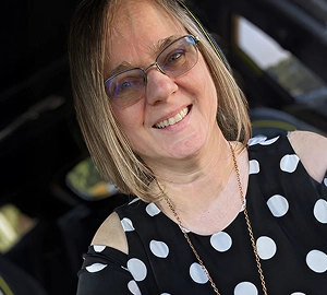 A real patient smiling in their car, sharing their story of managing their vitiligo with Opzelura.