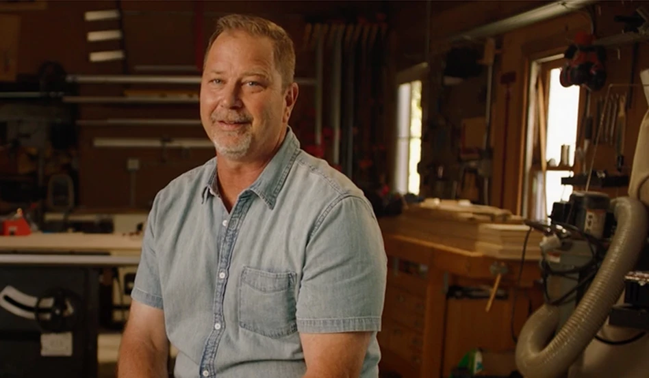 A real patient smiling and sitting in a workshop setting, sharing his Moments of Clarity with eczema and Opzelura.