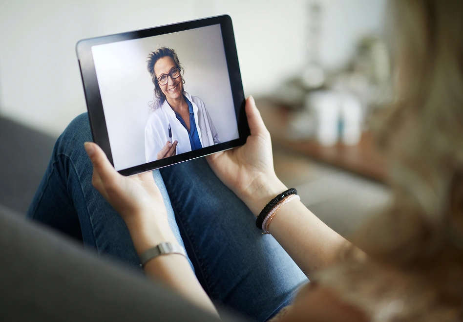 Person holding a tablet during a telehealth appointment.