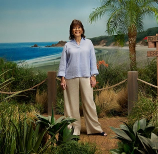 Rissa standing and smiling on a hiking trail setting, discussing her vitiligo repigmentation with Opzelura. 