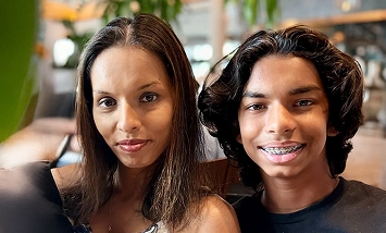 A real patient and caregiver smiling, arm in arm, sharing their story of managing vitiligo with Opzelura.