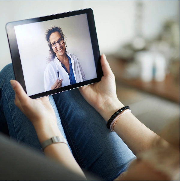 Person holding a tablet during a telehealth appointment.