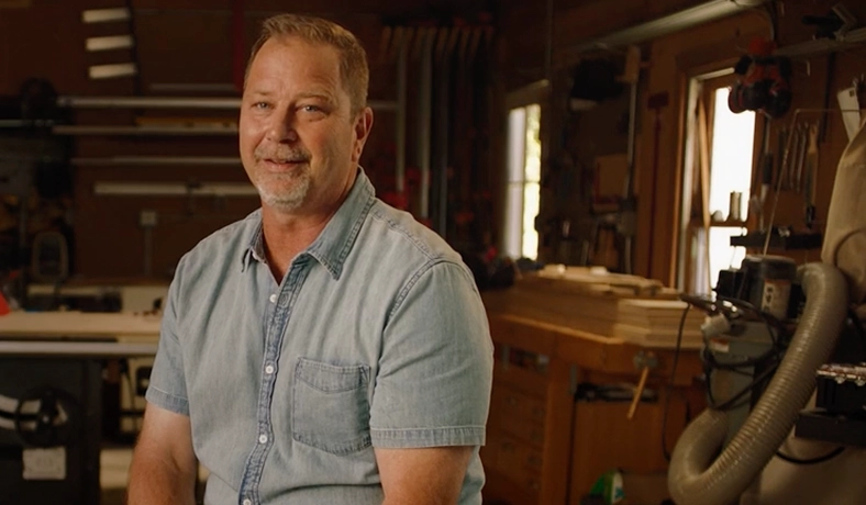 A real patient smiling and sitting in a workshop setting, sharing his Moments of Clarity with eczema and Opzelura.