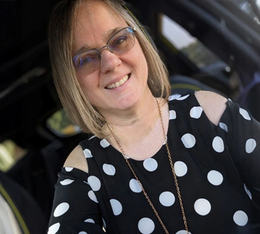 A real patient smiling in their car, sharing their story of managing their vitiligo with Opzelura.