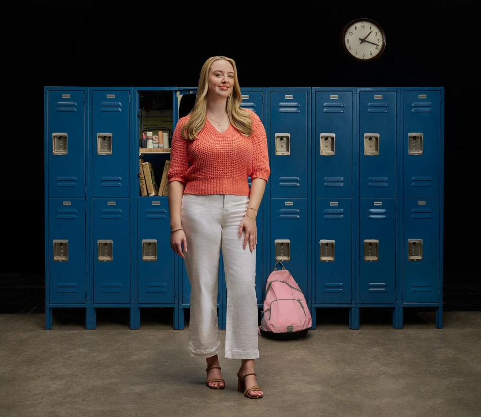 Sam standing in front of lockers, discussing her journey managing vitiligo with Opzelura.
