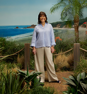 Rissa standing and smiling on a hiking trail setting, discussing her vitiligo repigmentation with Opzelura. 
