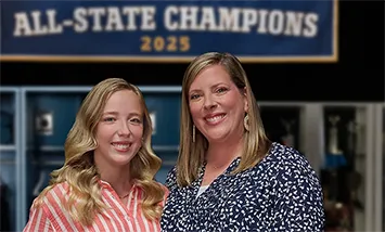 Anna and Rachael standing in front of an All-State Champions sign sharing their Moments of Clarity as they discuss managing eczema with Opzelura.